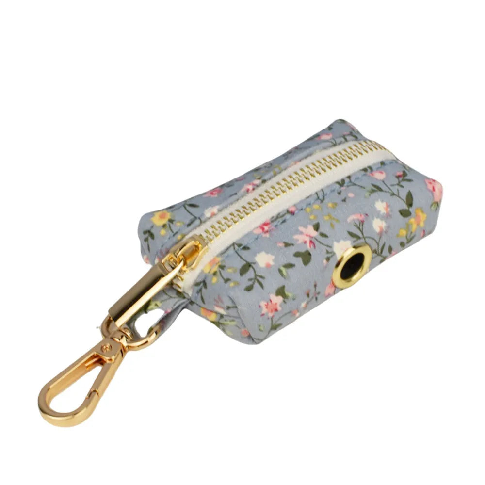 Blue floral pattern dog collar accessories set with adjustable collar, matching leash, bow, vest, and poop bag