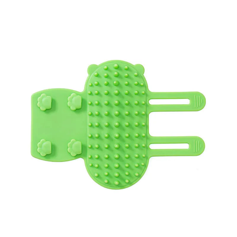 Silicone wall-mounted cat grooming brush with comb teeth and adjustable strap for table legs.