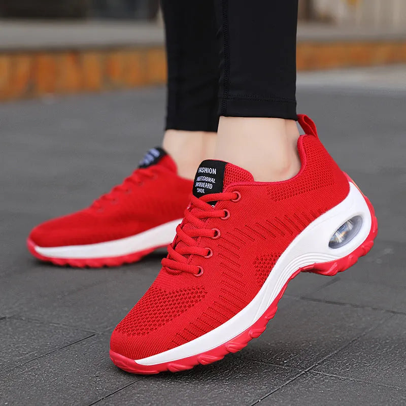 Women's black mesh sneakers with lace-up front and round toe, showing mid-heel height