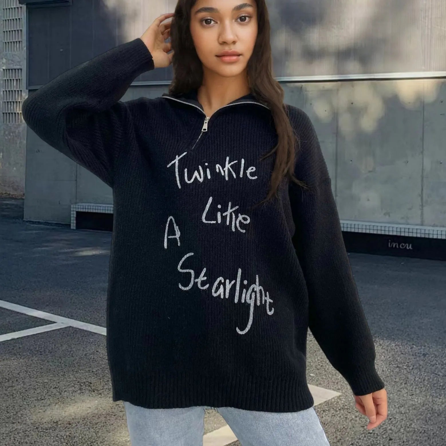 Woman wearing a light khaki retro pullover sweater with loose lapels, an oblique zip, and a text print.