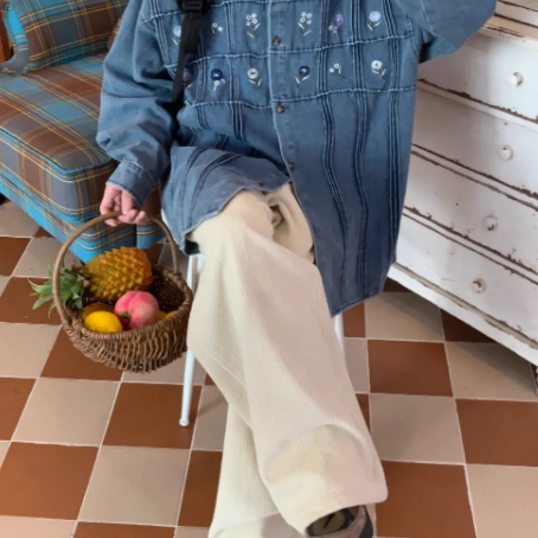 Washed blue denim shirt with small floral pleated detailing and button front closure
