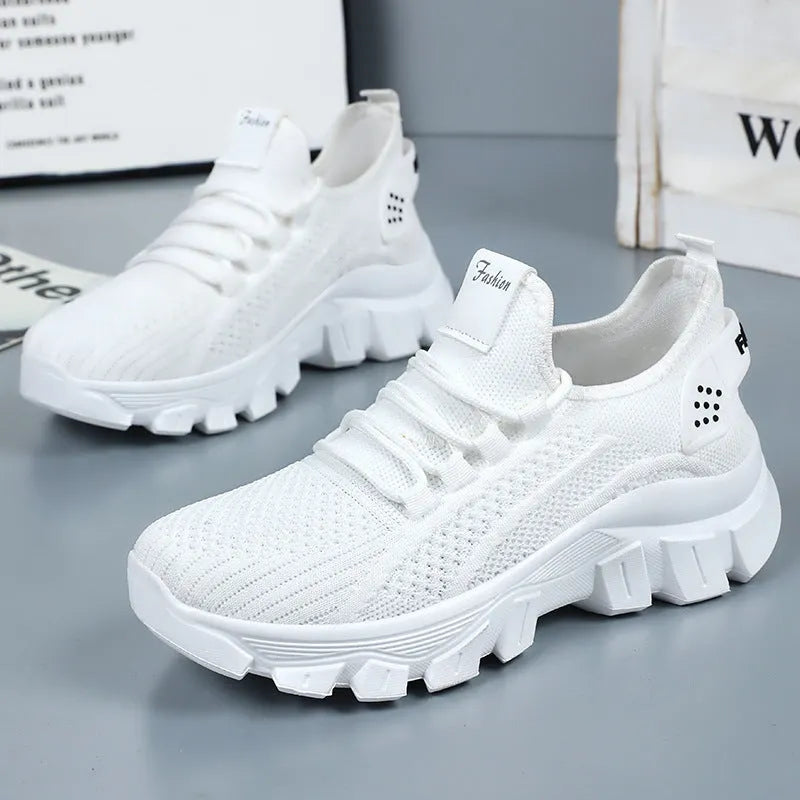 Women's white Flyknit sneakers with thick PVC sole and lace-up front.