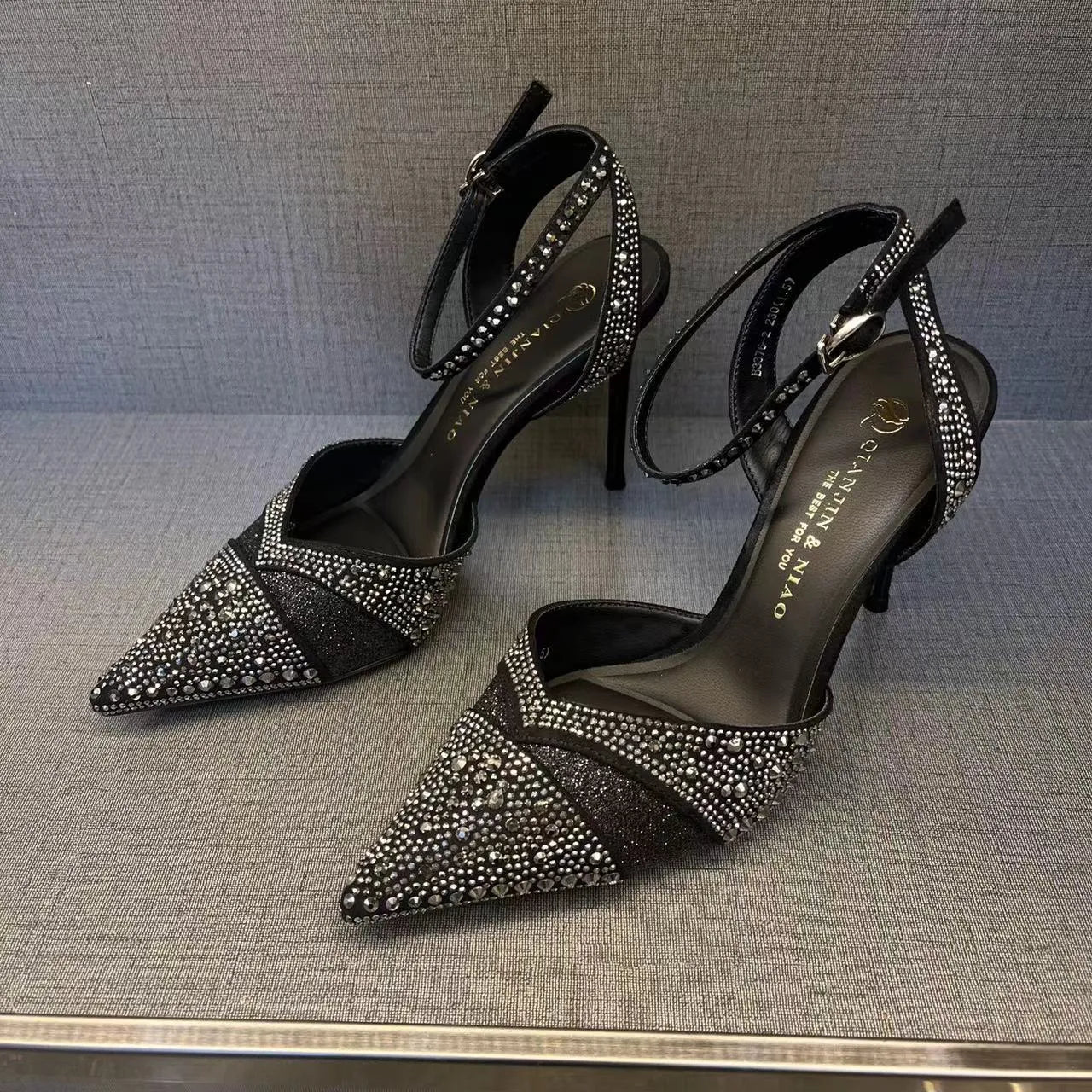 Women's black and silver hollow-cut stiletto high heels with pointed toes and red soles.