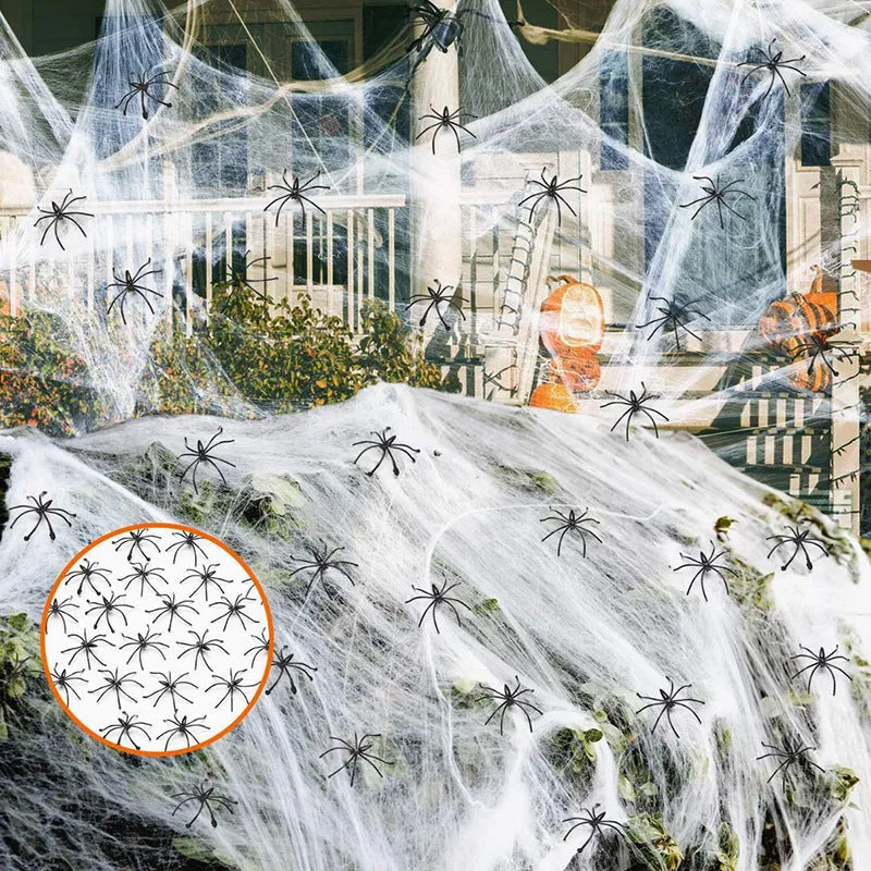 White cotton Halloween spider web decoration with plastic spiders on dark background