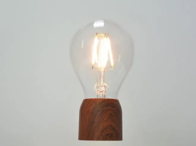 Magnetic levitation floating light bulb with imitation wood base and glass enclosure