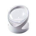 White clear plastic tilted cat food bowl on a flat surface.