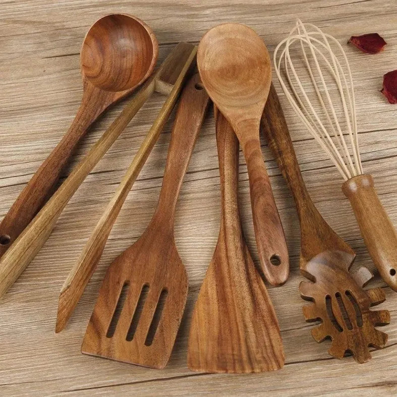 Seven-piece set of wooden cooking utensils including spoons and shovels on a kitchen counter.