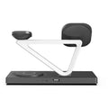 White five-in-one wireless charging station with magnetic phone bracket, circular charger, watch pad, and night lamp on desk.