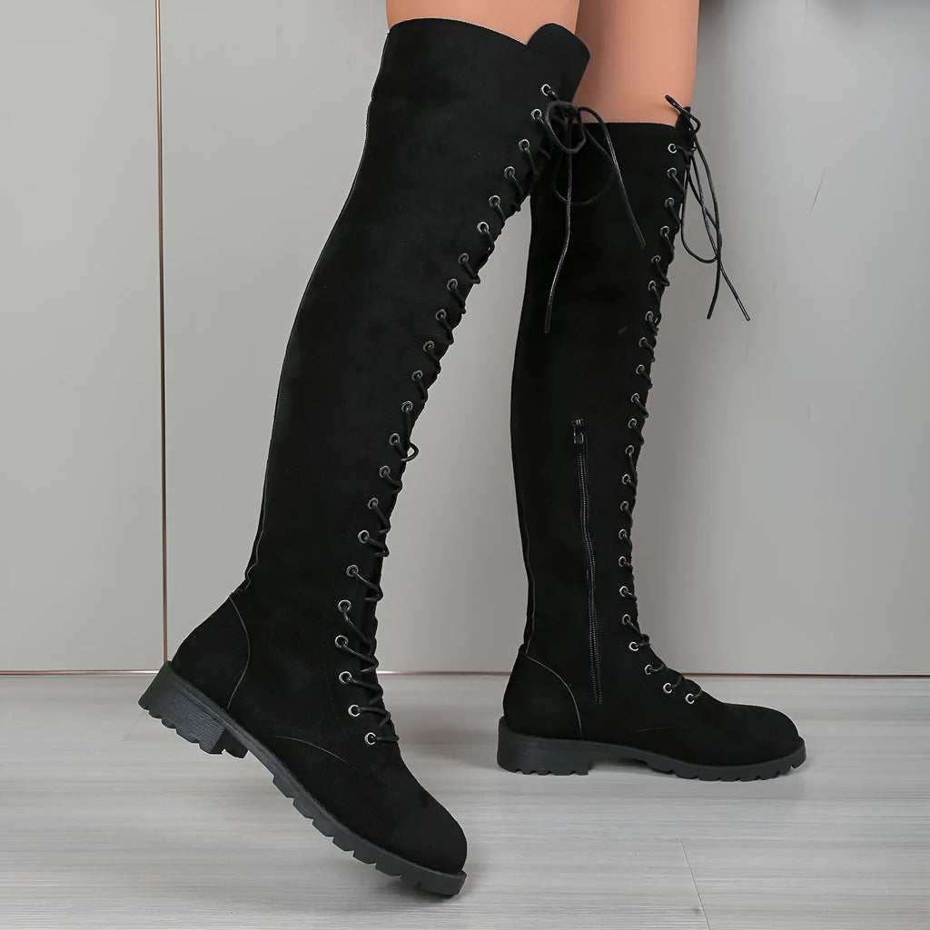 Black lace-up over-the-knee boots with round toe and flat heel on a neutral background.