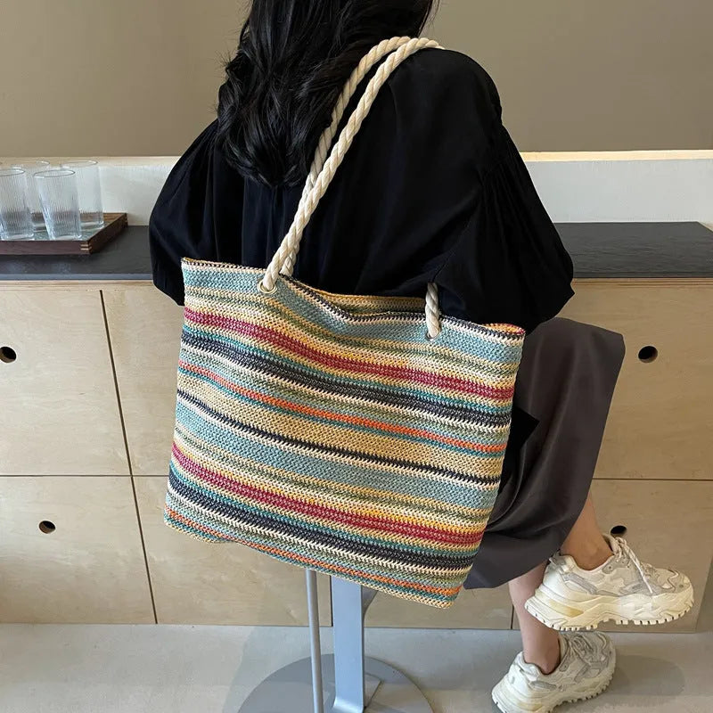 Blue straw woven nylon shoulder bag with a large capacity and polyester lining.