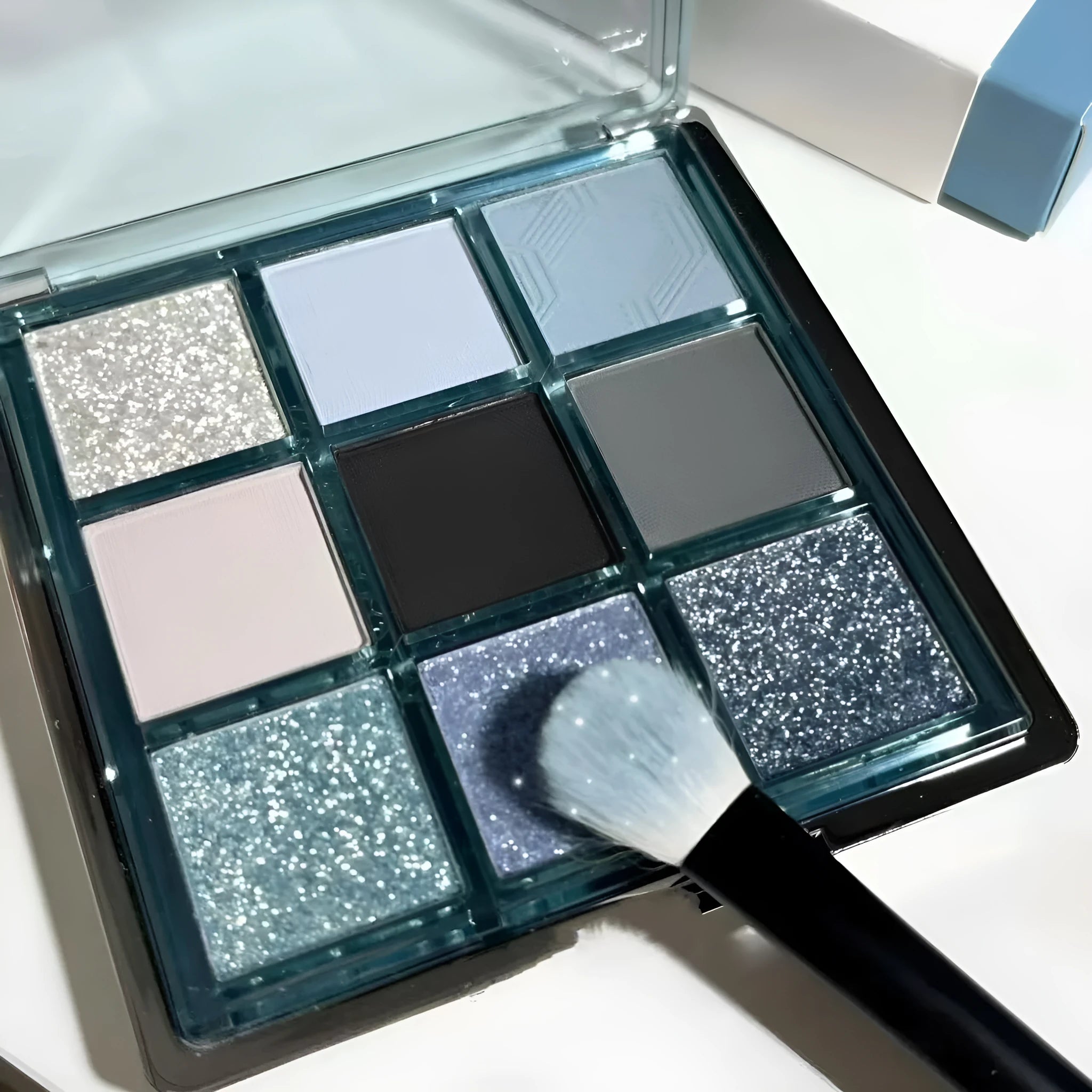 MUGELEEN nine-colour eye shadow palette showing blue smoked earth tones with matte and shimmer textures
