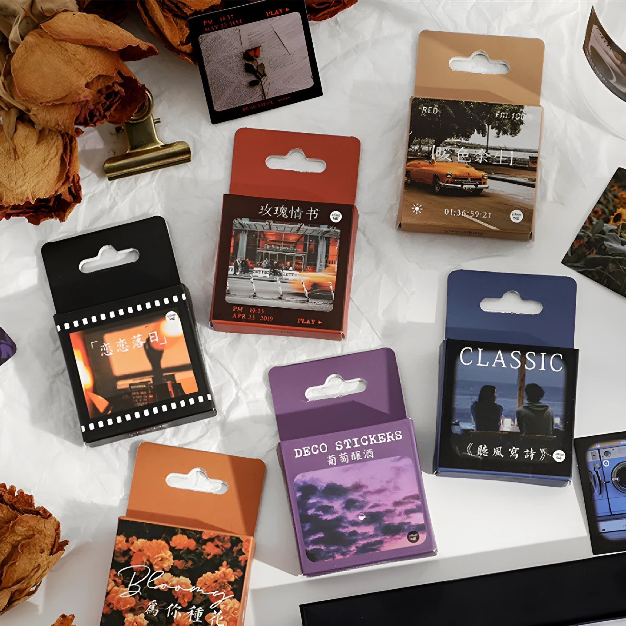 Box of Nordic-themed decorative stickers showing designs like flowers, roses, and sunset scenes, each sticker 44mm square.