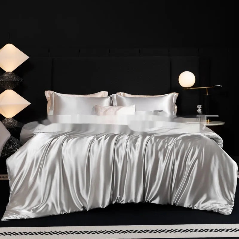 Silk bed sheet four-piece set in a solid colour, shown draped over a bed in one of seven available colours.
