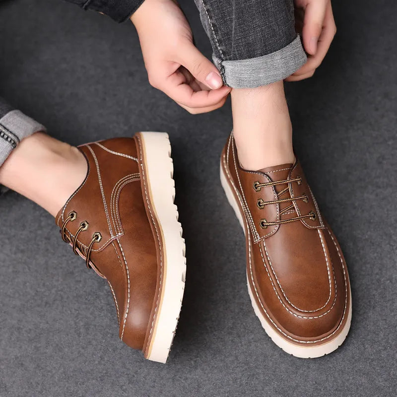 Men's black low-top Martin boots with round toe and rubber sole on wooden surface