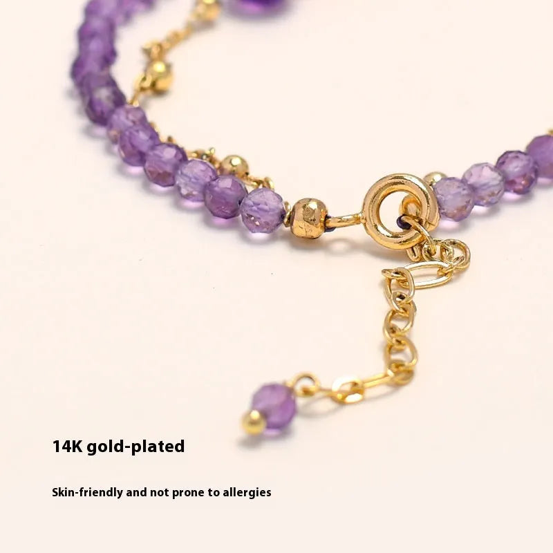Close-up of a Chinese style women's bracelet with diamond-shaped amethyst crystal beads and an electroplated finish.