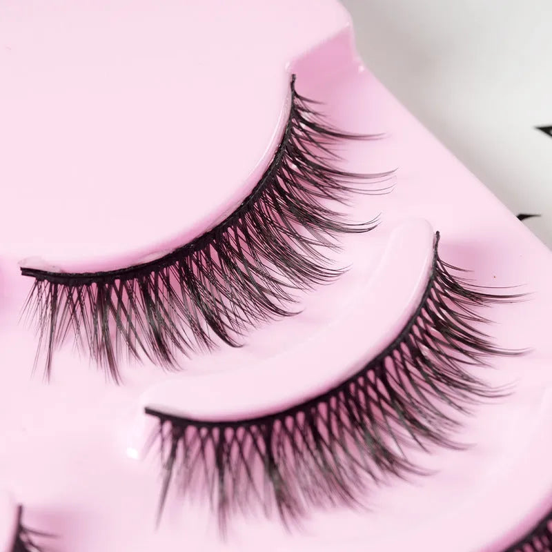 Five pairs of wispy manga-style false eyelashes on a plastic black terrier base for cosplay.