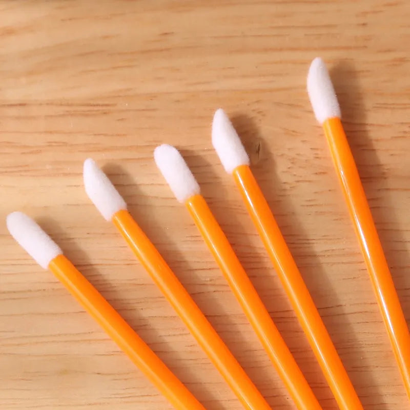 Pack of disposable lip brushes with flocked heads and coloured handles, shown in quantities from 200 to 500 pieces.