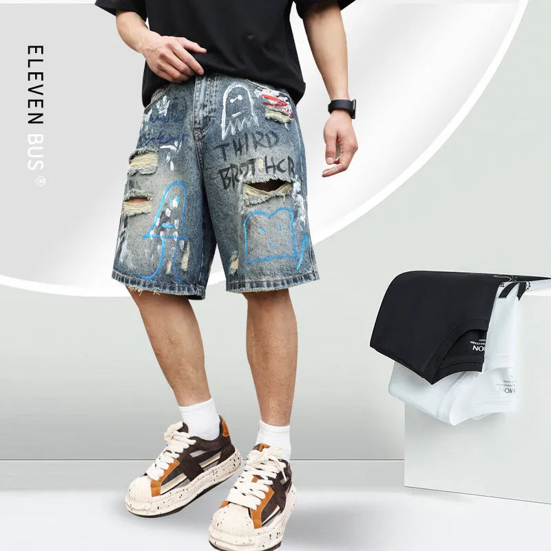 Blue ripped men's denim shorts with graffiti print and straight-leg cut.