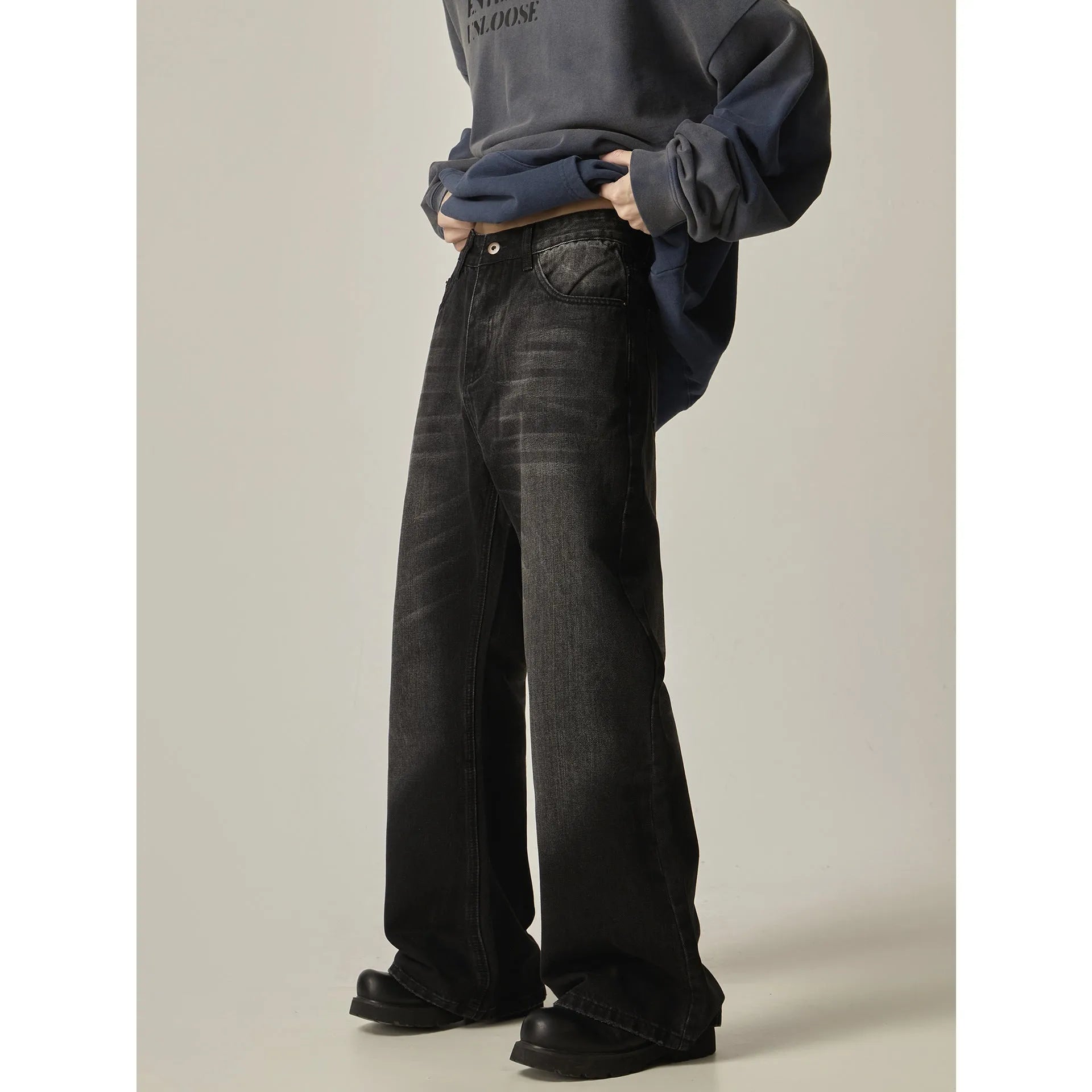Black loose straight leg retro jeans on a hanger, showing zipper fly detail.