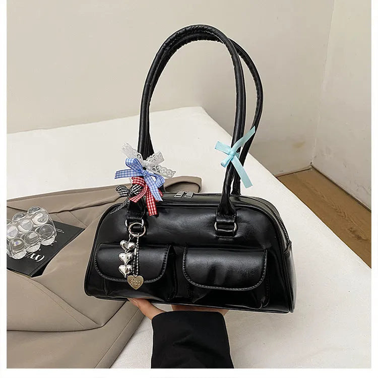 Brown PU leather women's pillow flap bag with double straps and a decorative ribbon pendant.