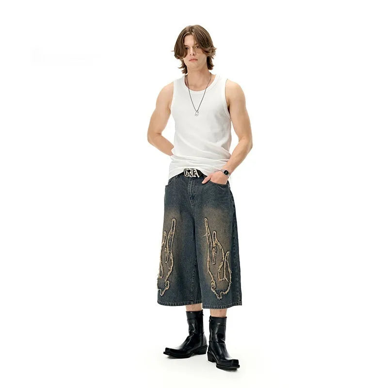 Men's black denim shorts with flame embroidery patch and cropped length for summer streetwear