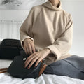 Woman wearing a solid apricot coloured loose fit long sleeve top with a half-high collar