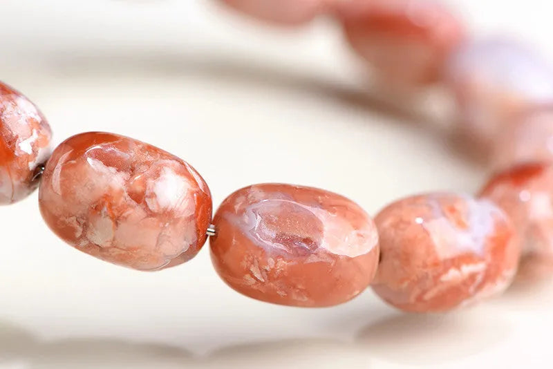 Natural cherry agate bracelet with geometric barrel beads and a Ruyi design detail.