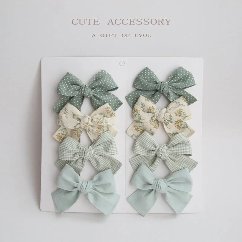 Children's dovetail bow hairclips in eight colour patterns including grid dots and floral designs