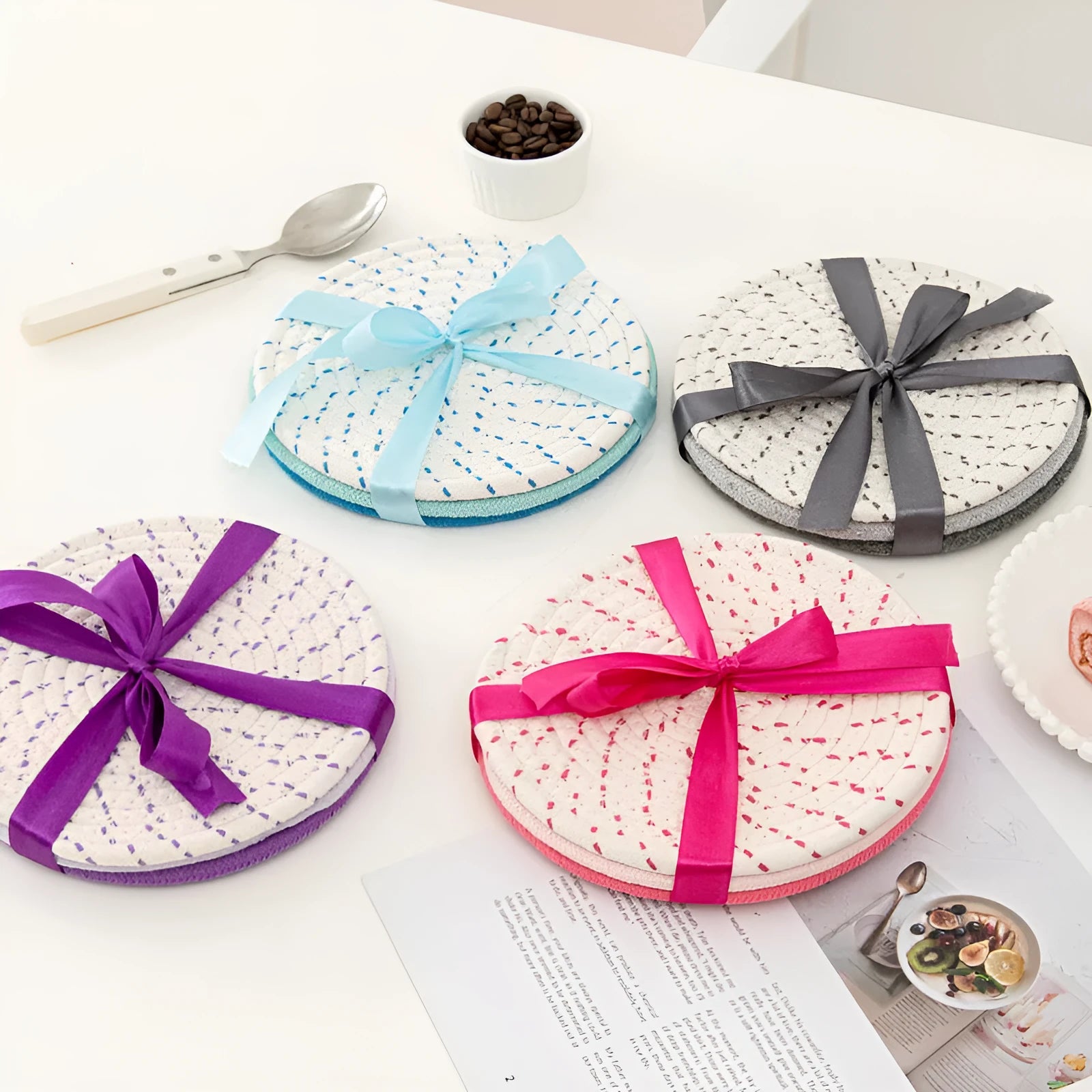 Set of three round grey cotton cord coaster placemats on a wooden table