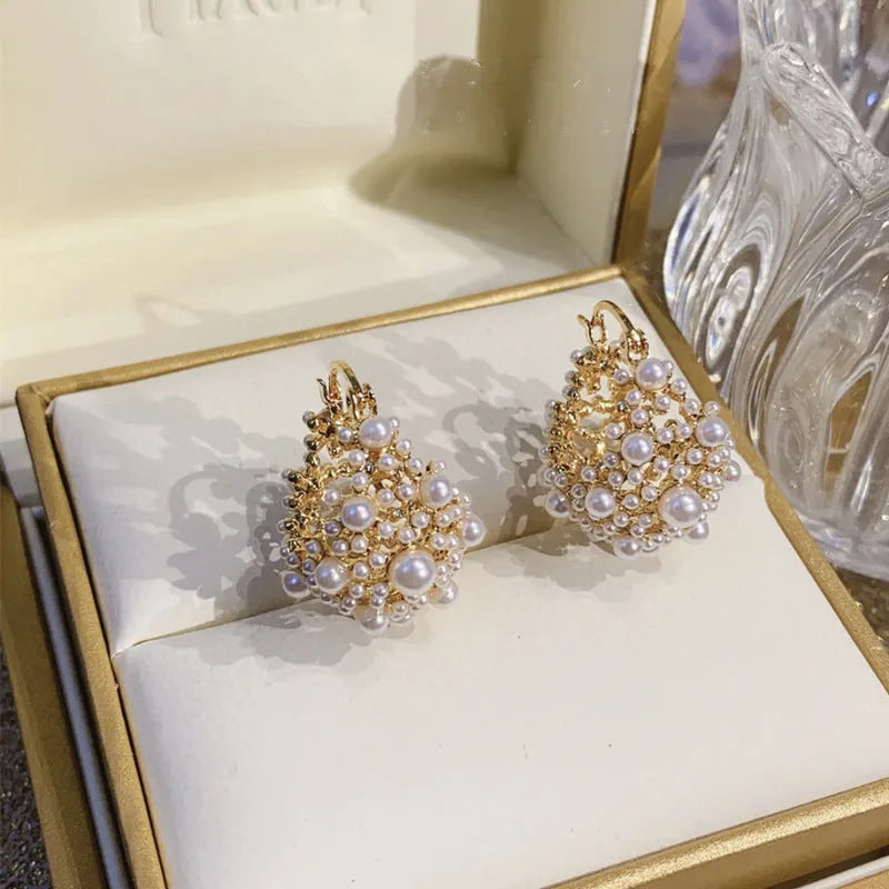Gold women's copper earrings in a flower basket shape decorated with small rice-shaped beads.