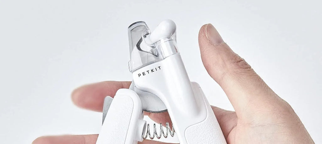 White LED pet nail clippers with transparent guard open, showing triangular steel blades and a nail file.