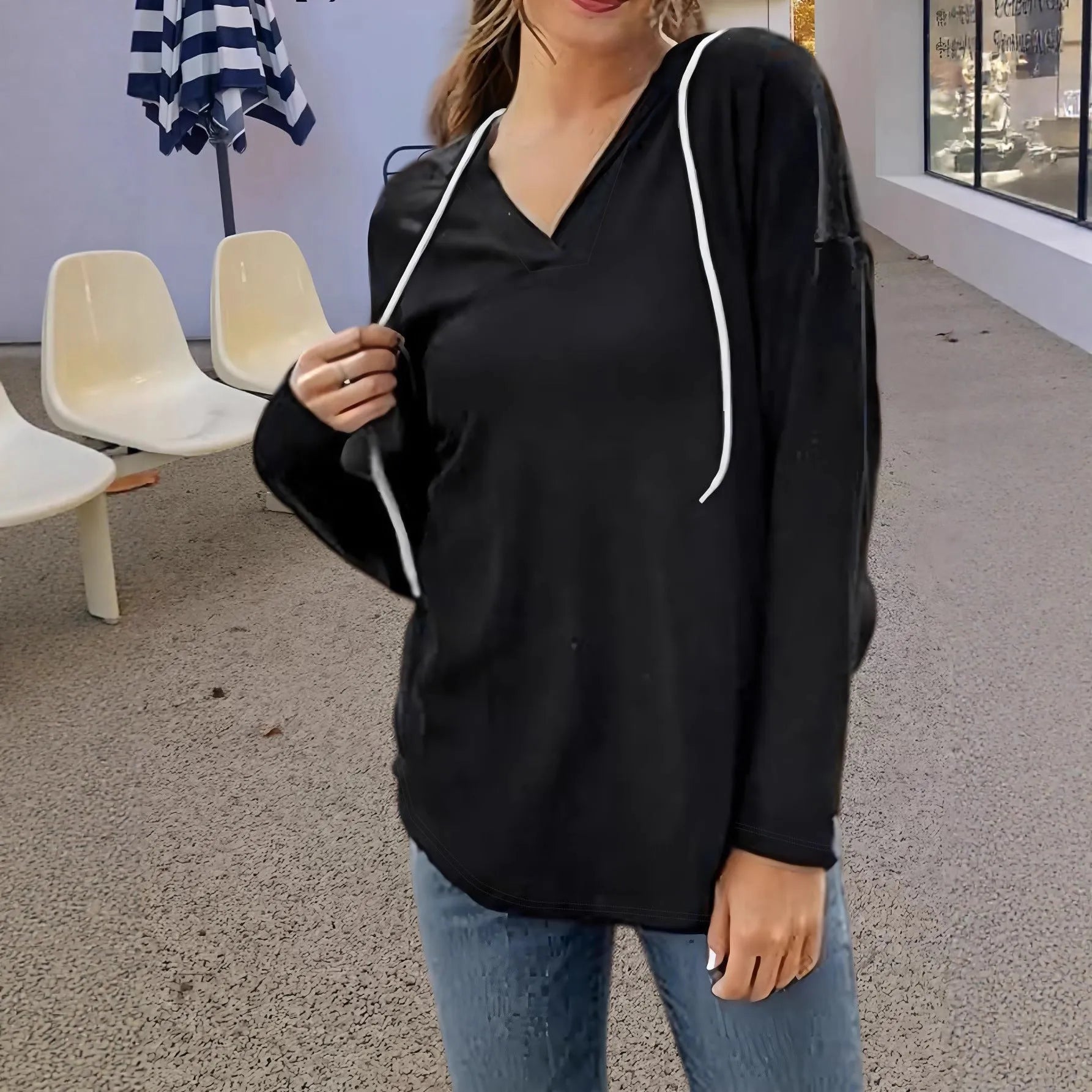 Women's red V-neck sweatshirt with hood showing loose fit and regular-length sleeves
