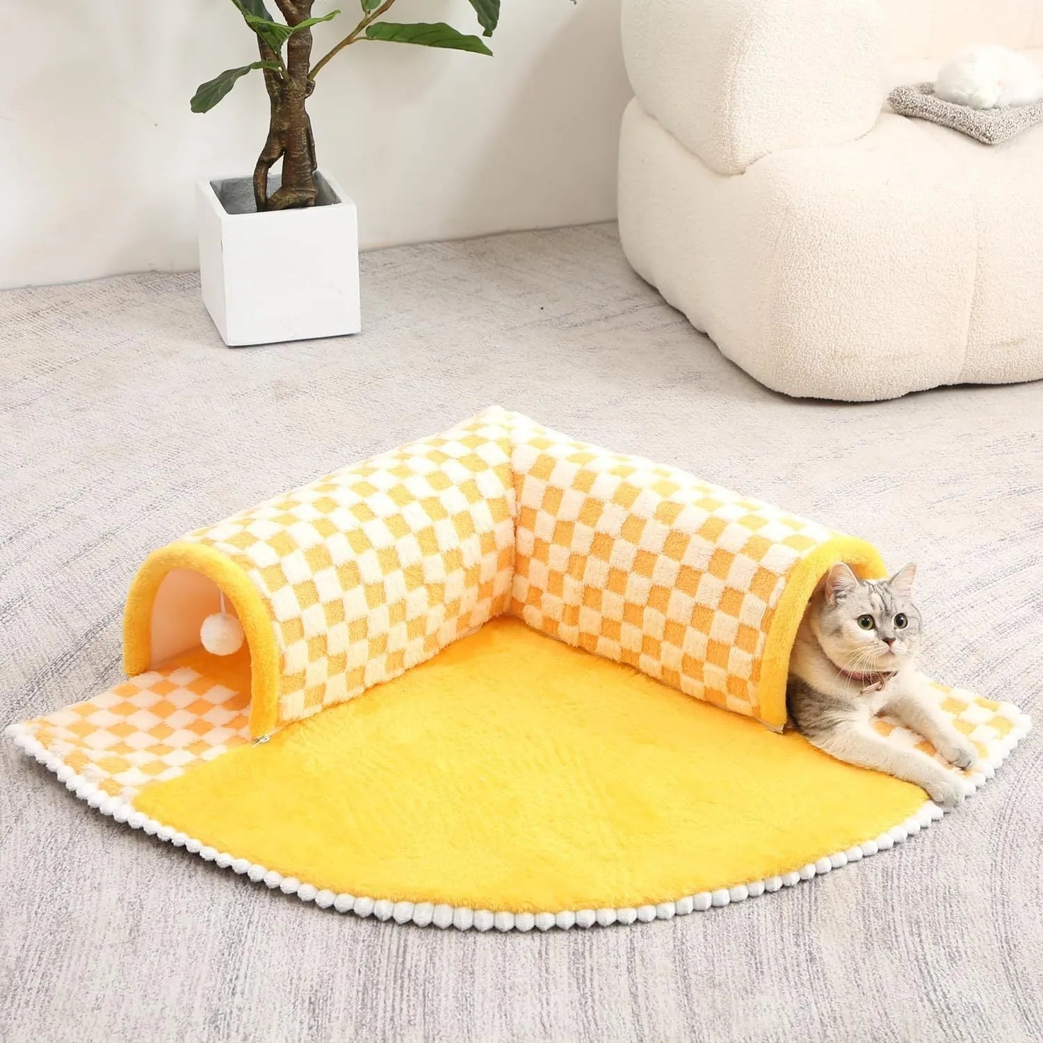 A plush fan-shaped dog and cat bed with an integrated tunnel, shown in a yellow plaid design.