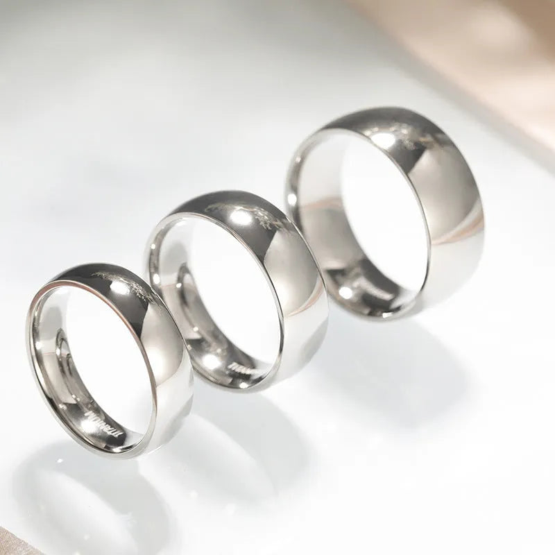 Silver titanium steel ring on a plain background showing its simple band design and grinding finish