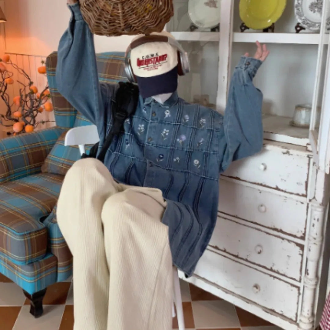 Washed blue denim shirt with small floral pleated detailing and button front closure