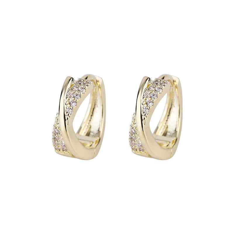 A pair of geometric stud earrings with zircon detail and 14K yellow gold plating on a copper base.