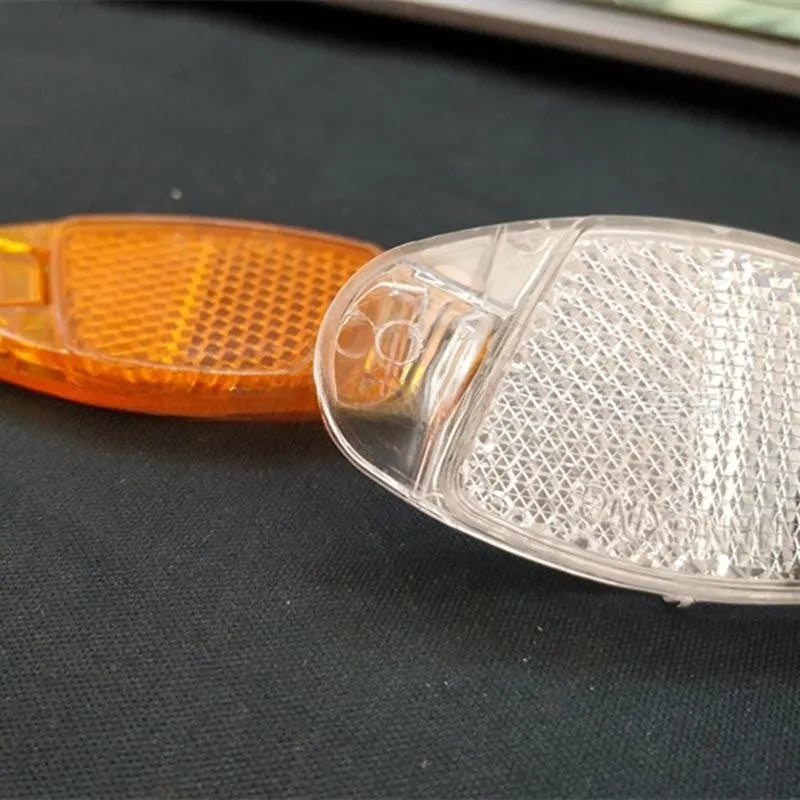 Yellow and white plastic bicycle reflector decorations mounted on wheel spokes for night safety