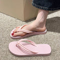 Women's pink PVC closed-toe flip flops with a non-slip sole on a plain background.