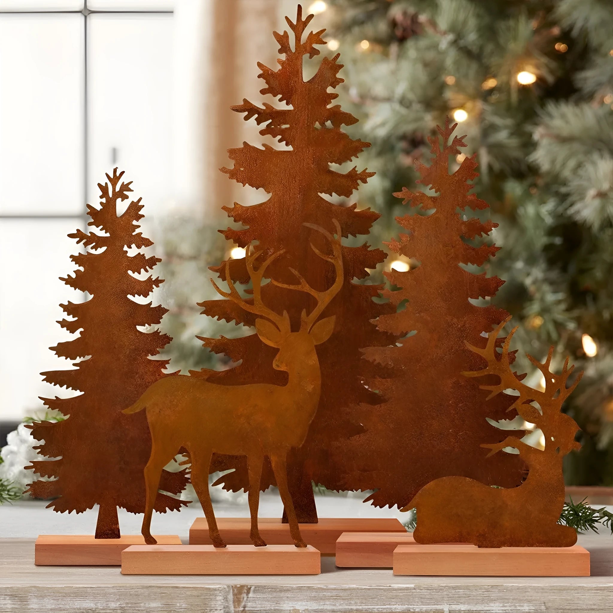 Three rustic metal Christmas tree ornaments shaped like elk with an oxidised iron finish.
