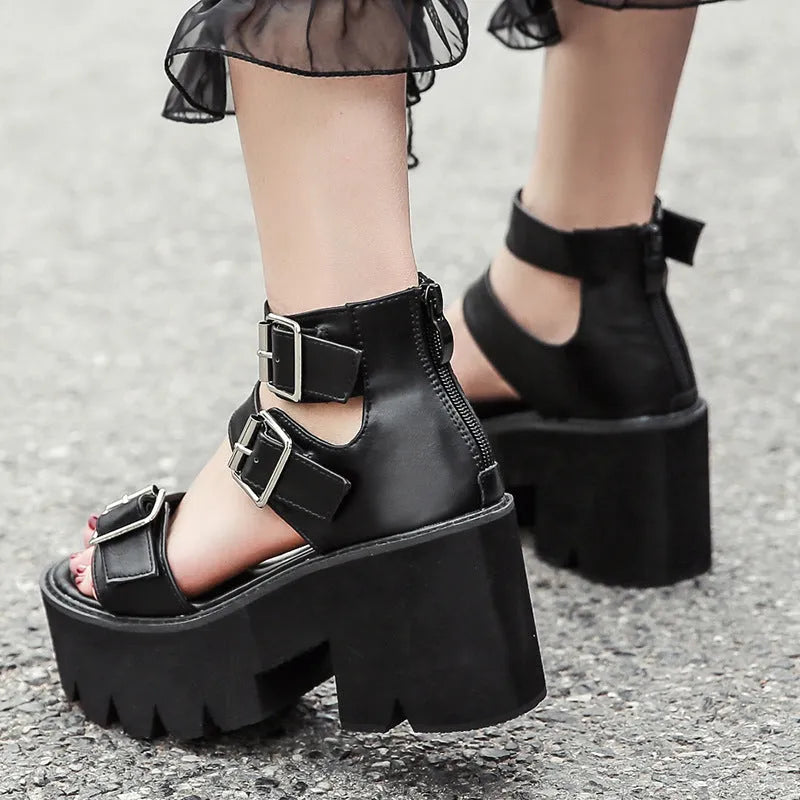 Black women's punk-style platform sandals with a chunky heel, thick sole, round toe, and back zipper.