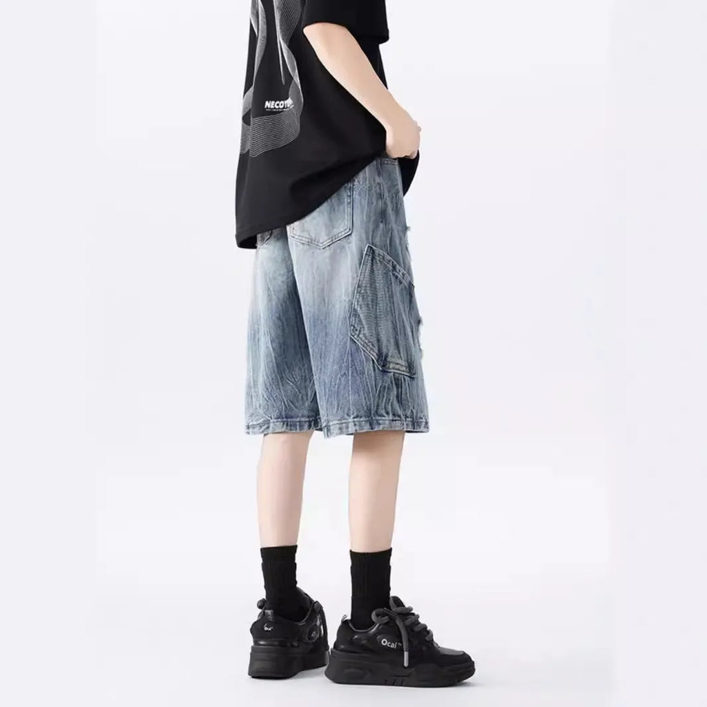 Loose-fit denim shorts with a washed fabric finish and ripped, distressed detailing on the legs.