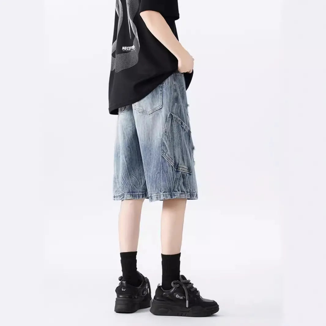Loose-fit denim shorts with a washed fabric finish and ripped, distressed detailing on the legs.