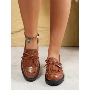 Brown women's pointed-toe loafers with a fabric bow detail on the vamp.