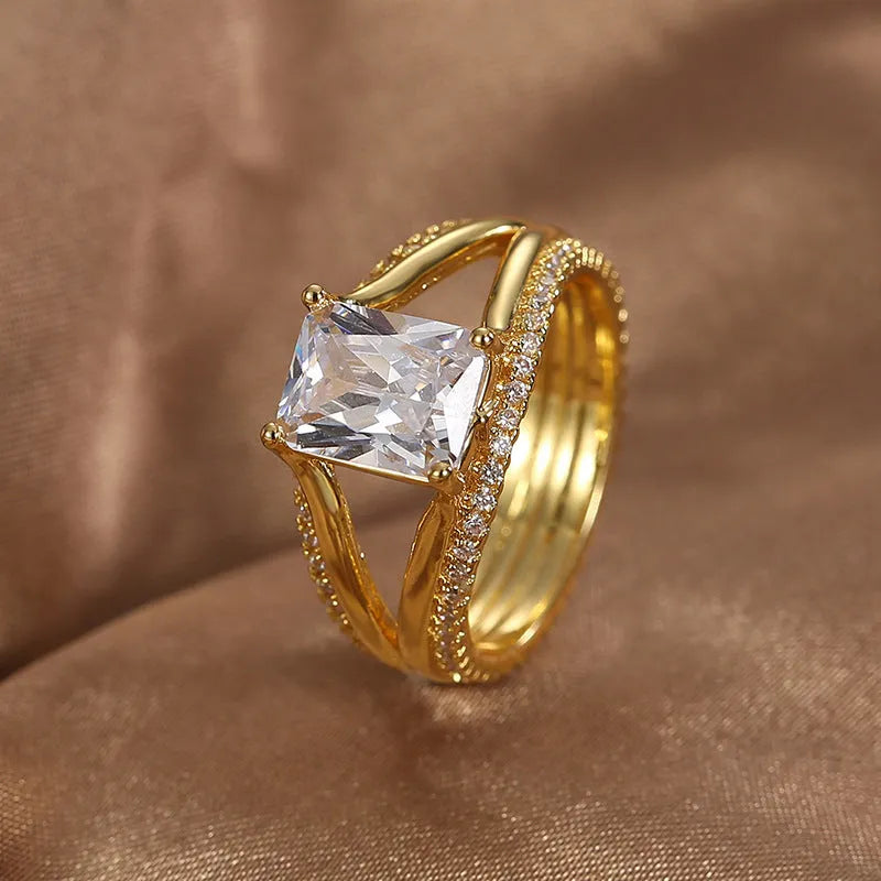 Gold geometric women's ring with a square zircon stone on a copper band.