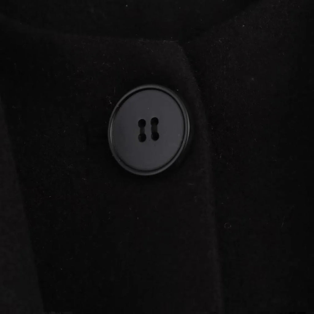 Women's long black polyester coat with a faux fur collar, shown in a street fashion style.
