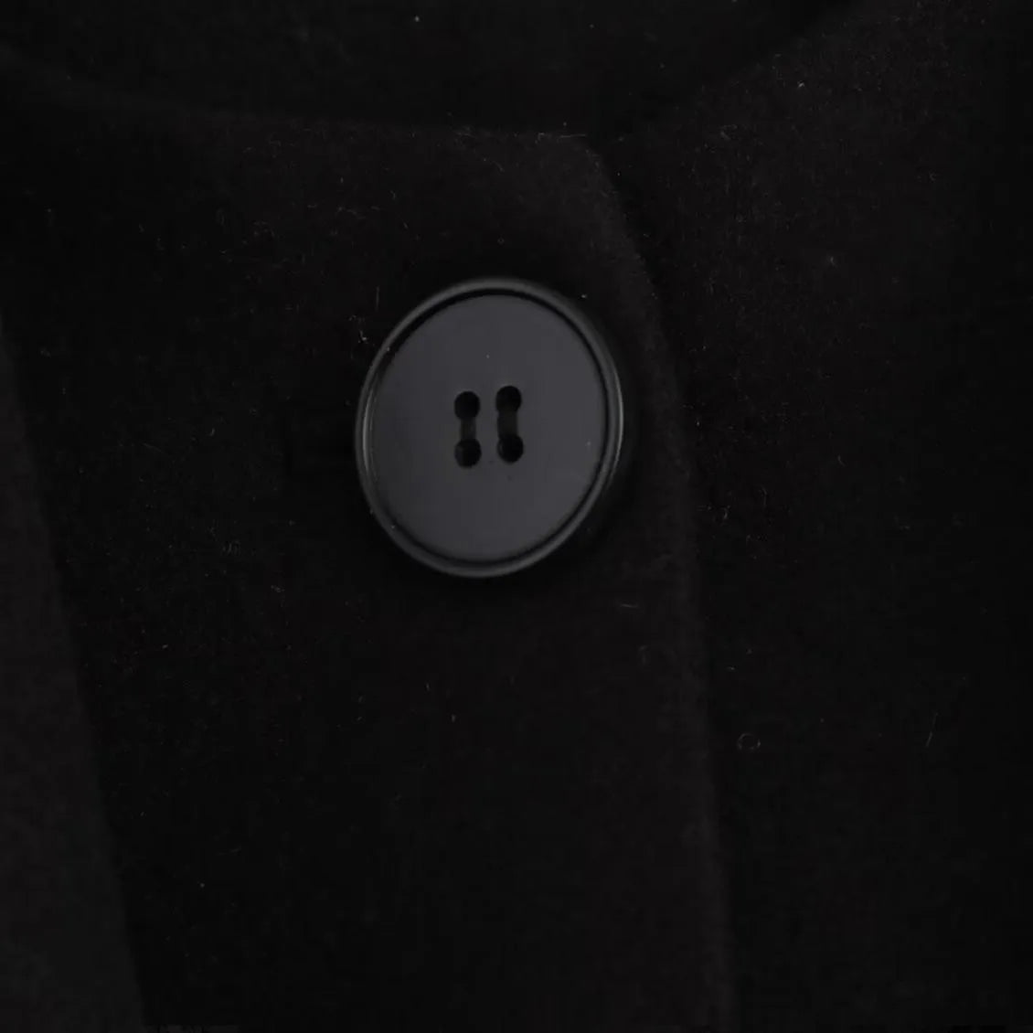 Women's long black polyester coat with a faux fur collar, shown in a street fashion style.
