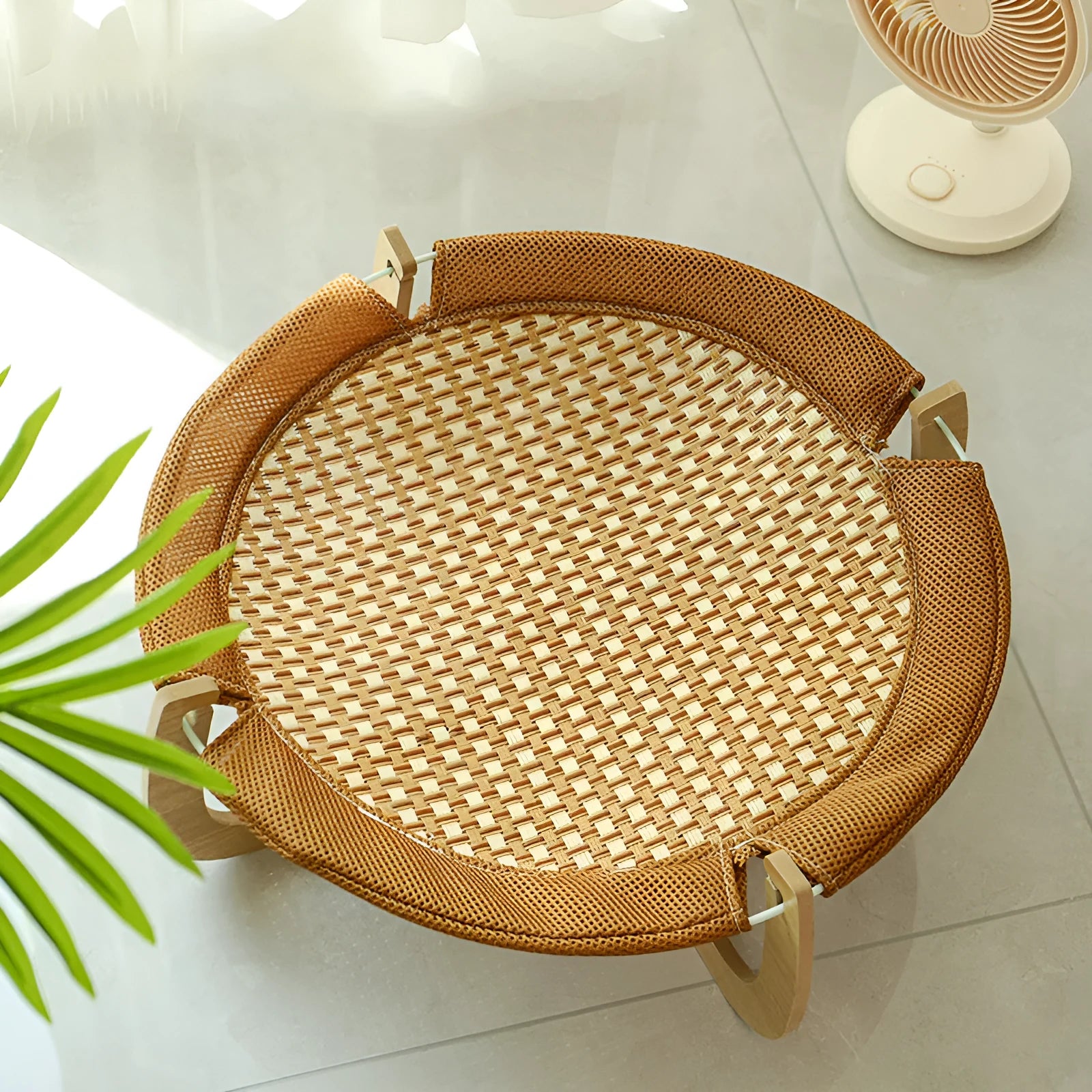 Brown woven rattan pet hammock bed for cats and small dogs on a white floor