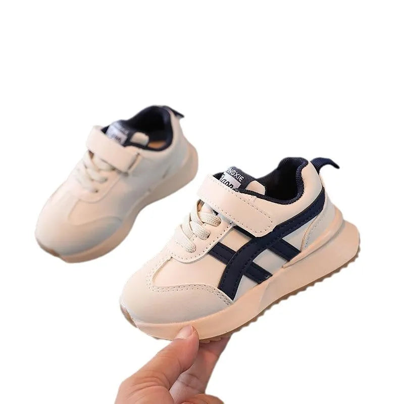 Children's white synthetic leather sneaker with a single Velcro strap and rubber sole.