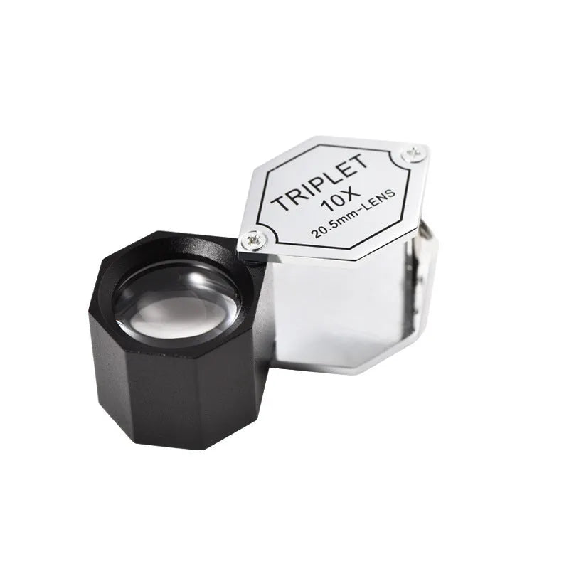 Handheld metal magnifying glass with optical glass lens for inspecting jewellery and coins.