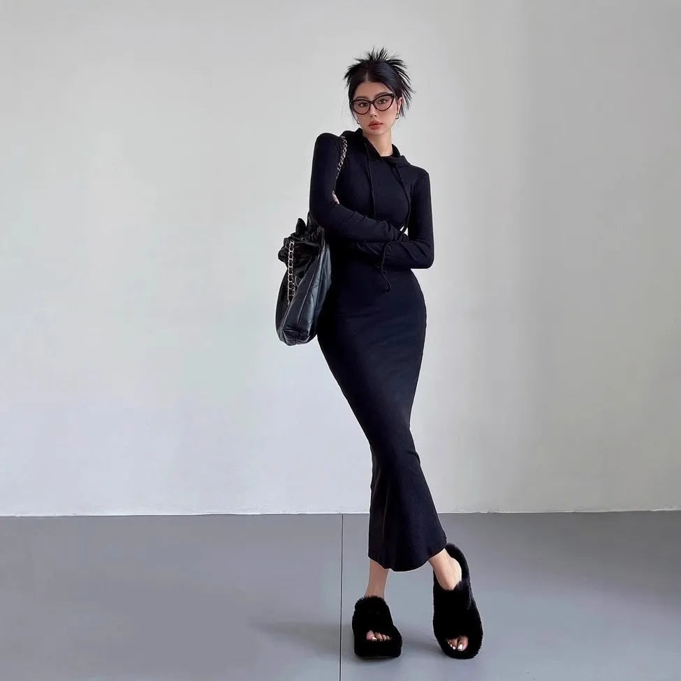 A woman modelling a grey hooded long sleeve sheath dress with a high waist.
